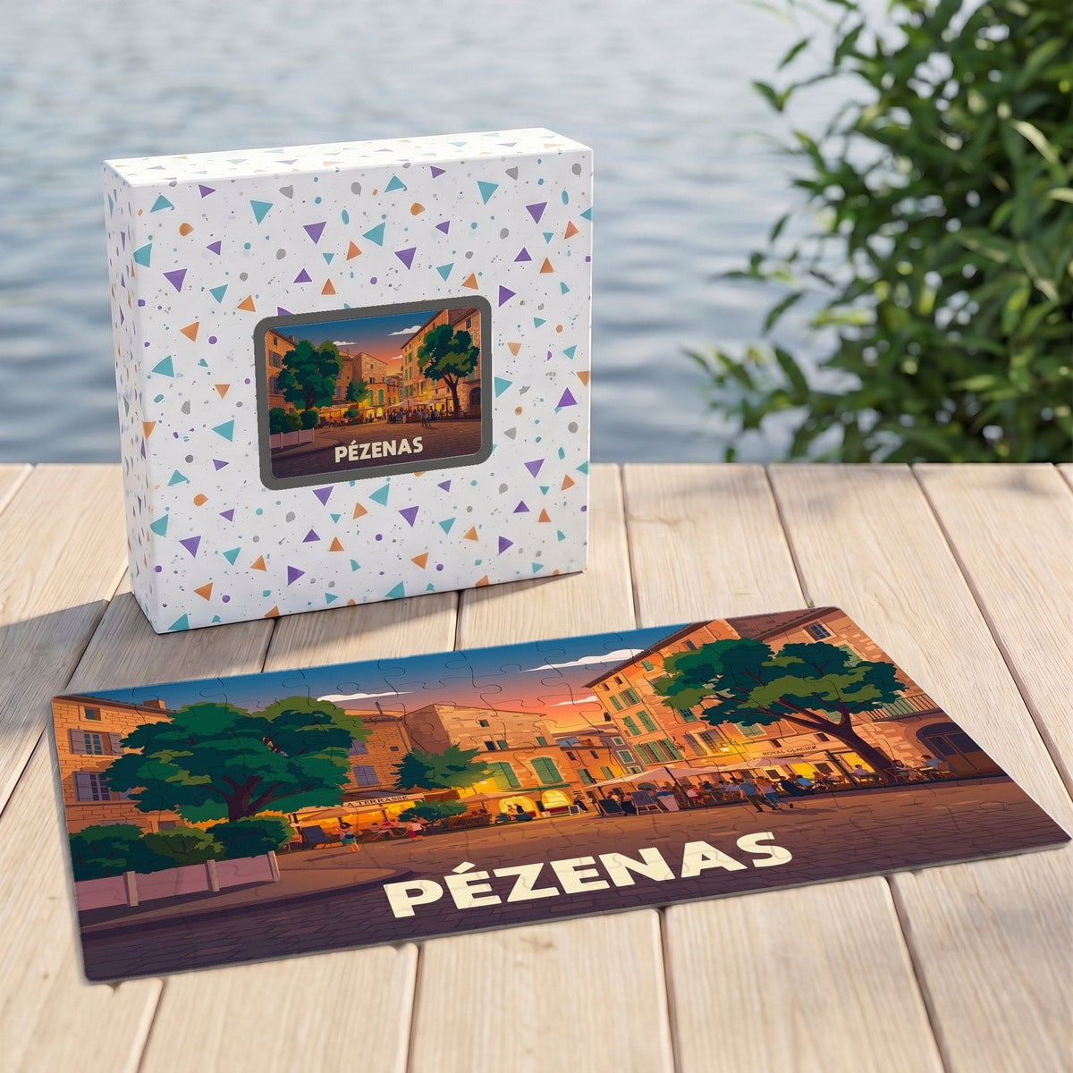 Puzzle souvenir de la ville de Pézenas avec une illustration stylisée d'une place animée au coucher du soleil.