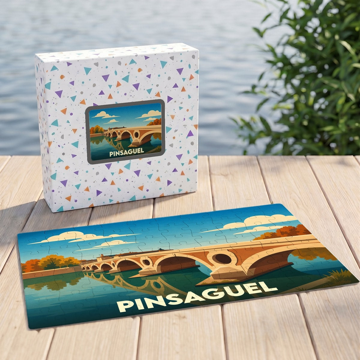 Puzzle souvenir de la ville de Pinsaguel avec une illustration stylisée d'un pont sur la rivière.