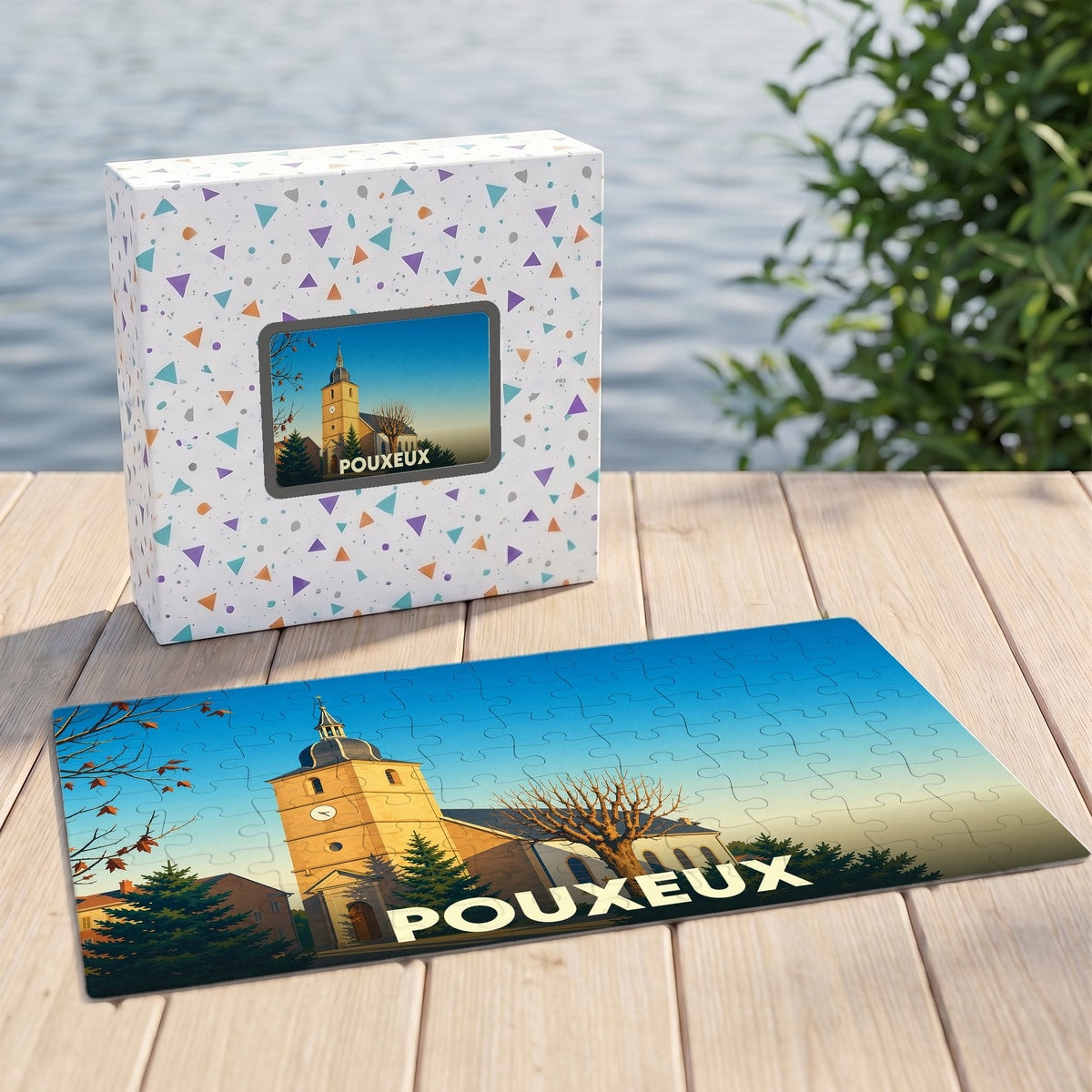 Puzzle souvenir de la ville de Pouxeux avec une illustration stylisée d'une église sur sa boîte assortie.