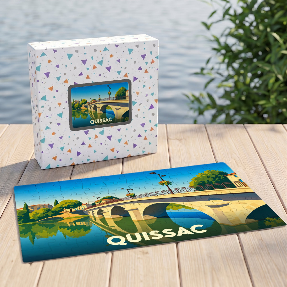 Puzzle souvenir de la ville de Quissac avec une illustration stylisée représentant un pont de pierre traversant une rivière.