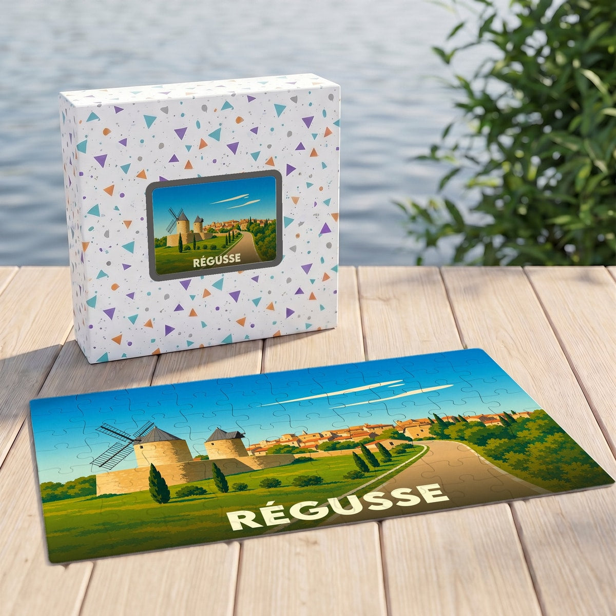 Puzzle souvenir de la ville de Régusse illustrant ses moulins emblématiques sur un fond de paysage provençal stylisé.