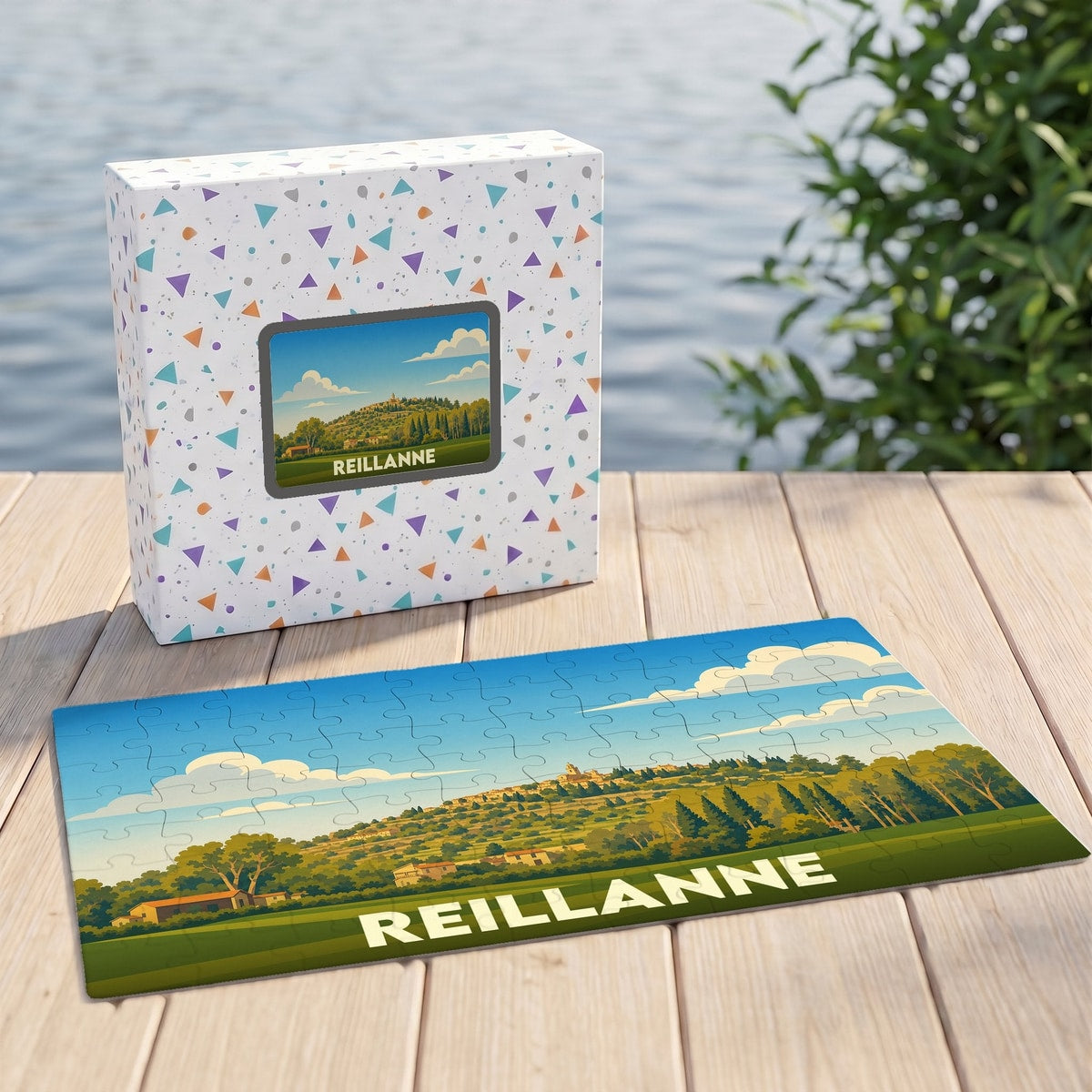 Puzzle souvenir de la ville de Reillanne présentant une illustration panoramique stylisée dans sa boîte assortie.