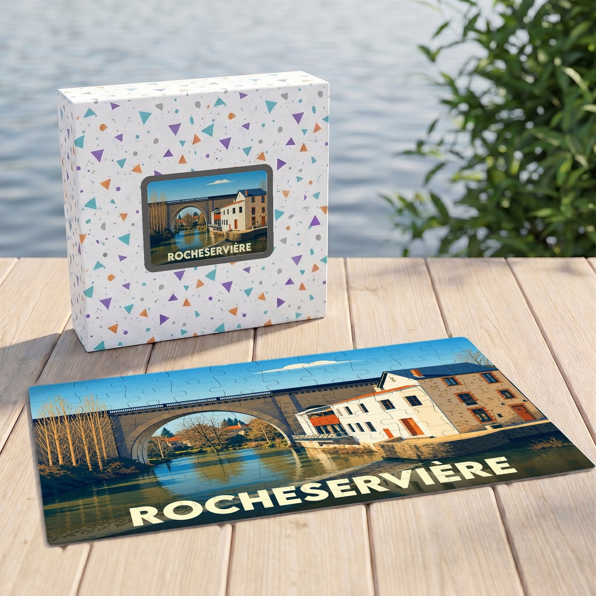 Puzzle souvenir de la ville de Rocheservière avec une illustration stylisée d'un pont et de maisons au bord de l'eau.