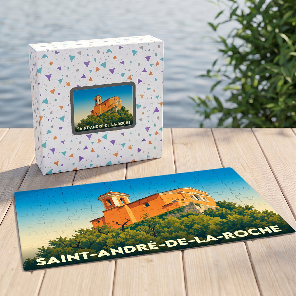 Puzzle souvenir de la ville de Saint-André-de-la-Roche illustrant une église provençale sur une colline arborée.