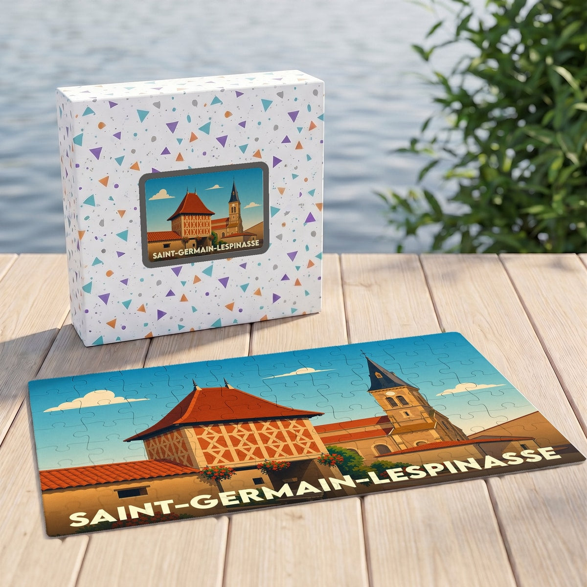 Puzzle souvenir de Saint-Germain-Lespinasse avec une illustration stylisée et sa boîte assortie posés sur un ponton.