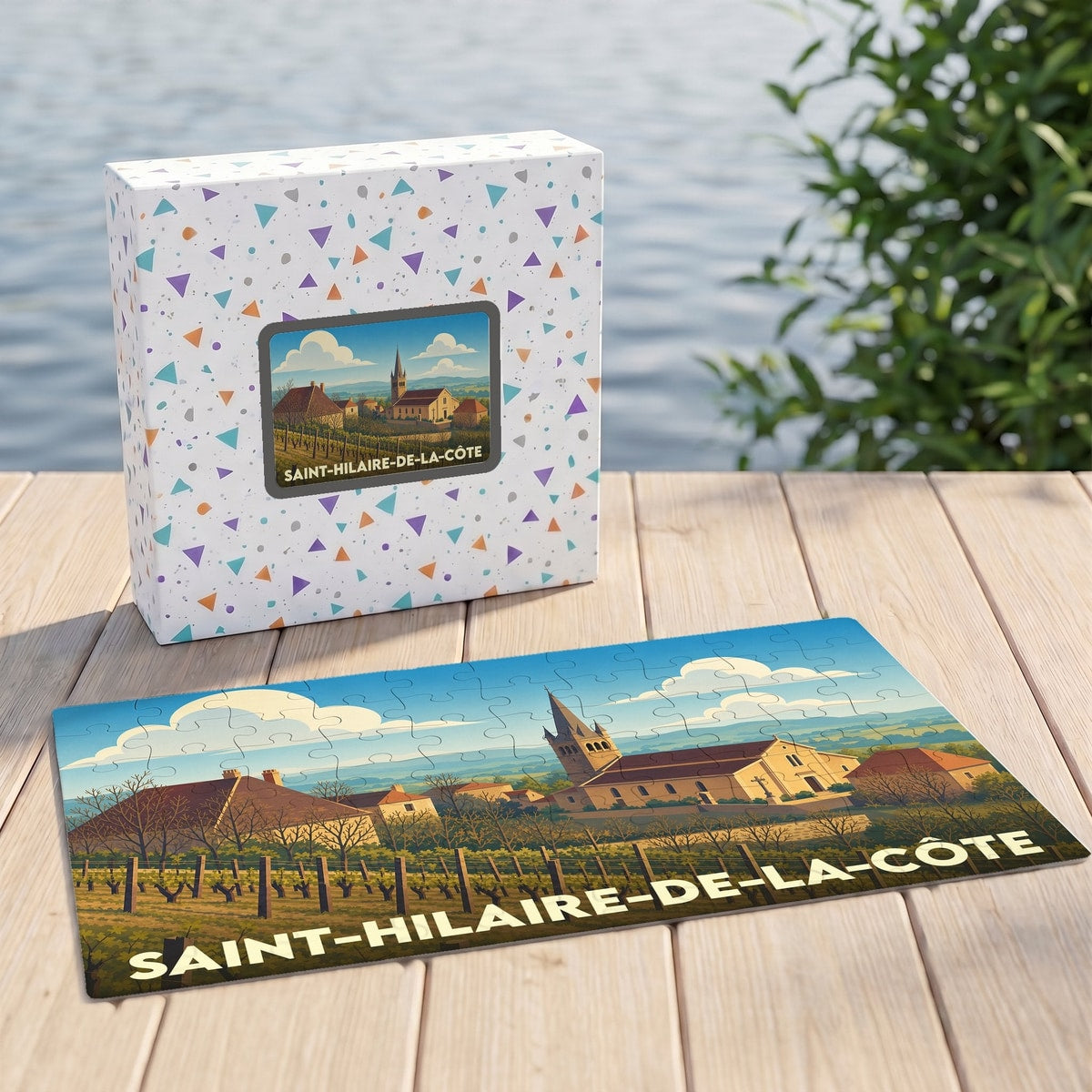 Puzzle souvenir de la ville de Saint-Hilaire-de-la-Côte avec son coffret et une illustration stylisée du village.