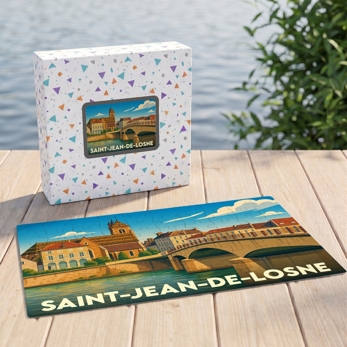 Puzzle souvenir de la ville de Saint-Jean-de-Losne avec son coffret, illustrant un paysage urbain au bord de l'eau.