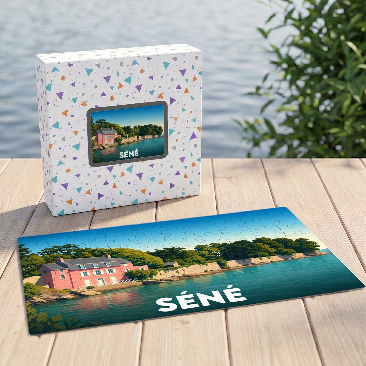 Puzzle souvenir de la ville de Séné présentant une illustration stylisée d'une maison rose en bord de mer.