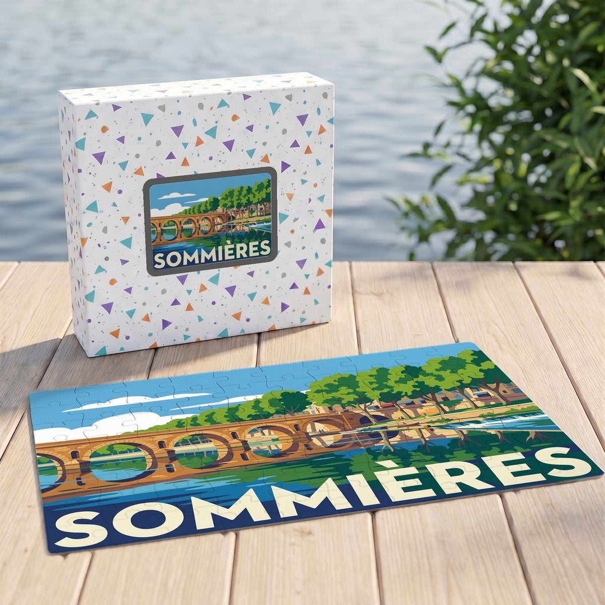 Puzzle souvenir de la ville de Sommières avec une illustration stylisée d'un pont et de son reflet sur l'eau.
