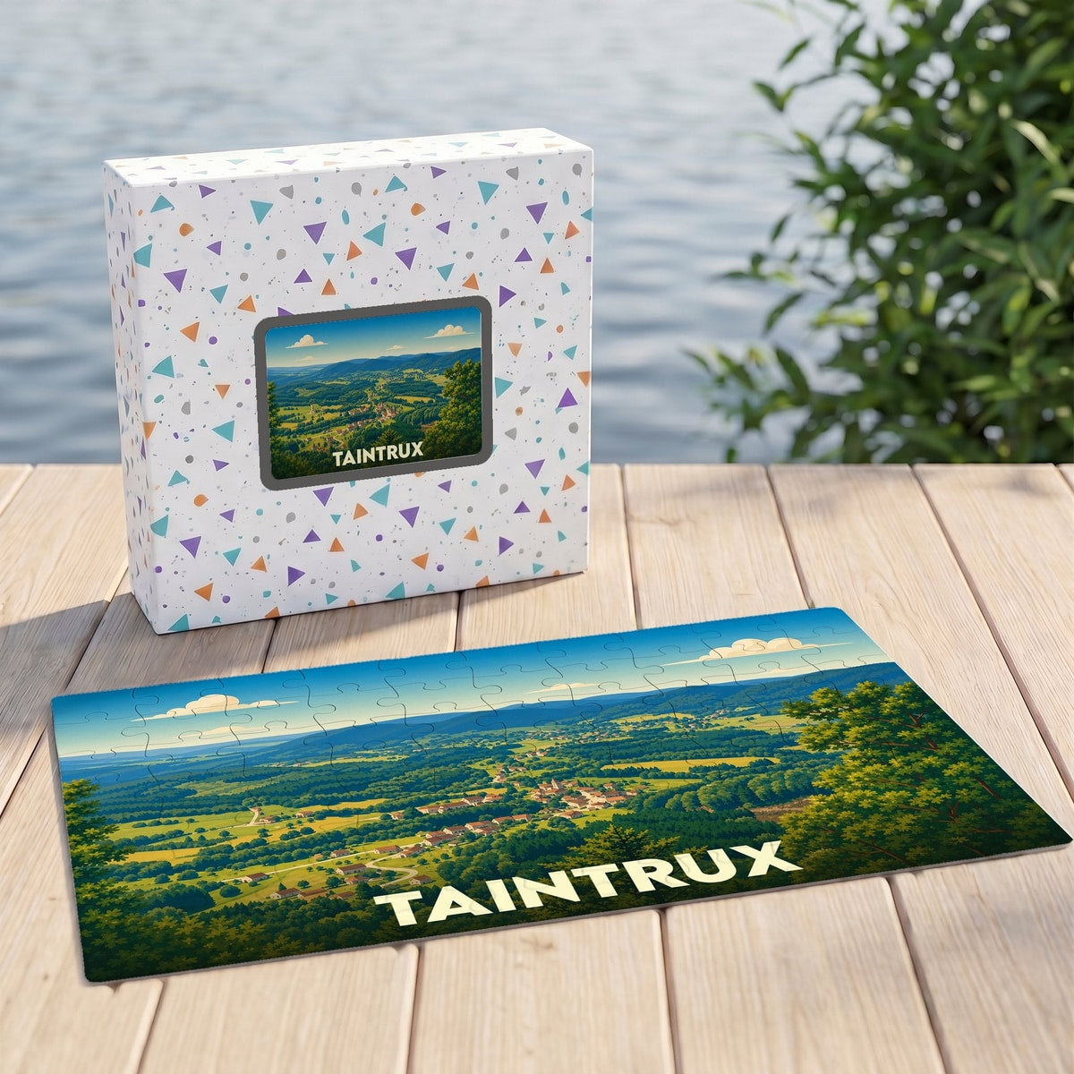 Puzzle souvenir de la ville de Taintrux avec une illustration stylisée d'un paysage de vallée verdoyant.