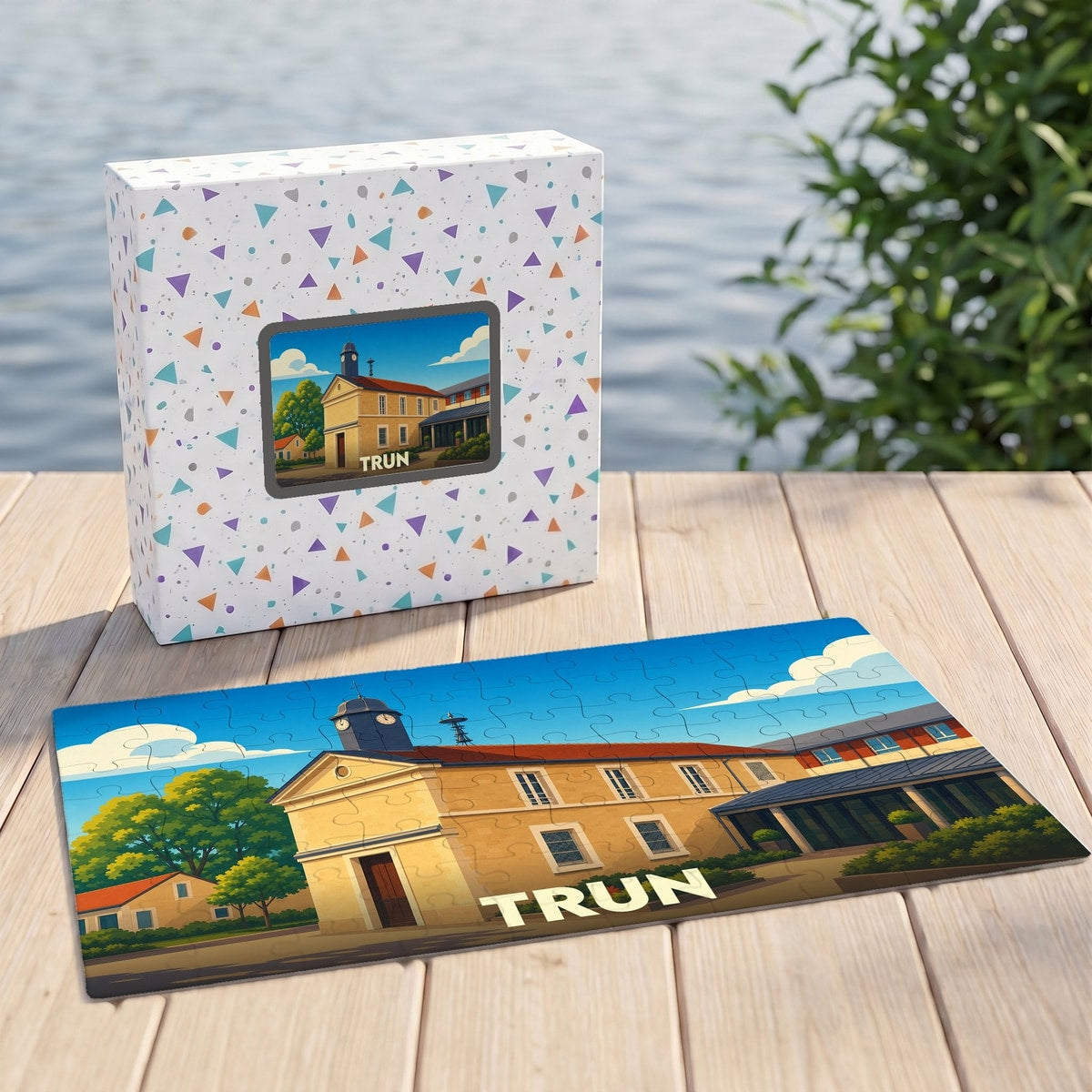 Puzzle souvenir de la ville de Trun avec une illustration stylisée de son patrimoine, présenté à côté de sa boîte.