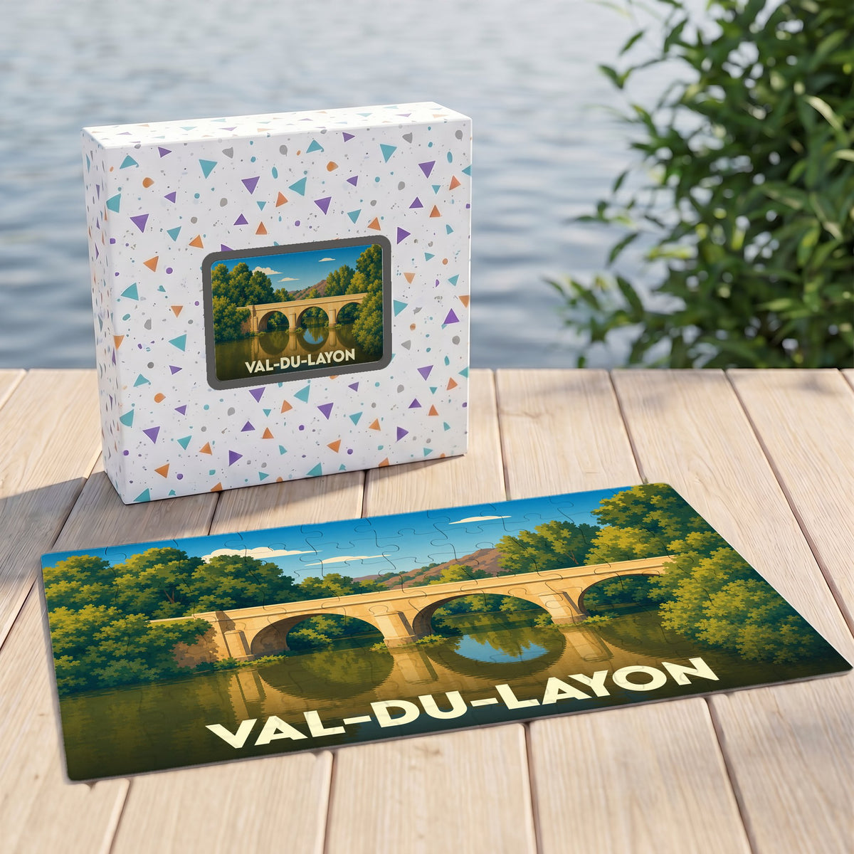 Puzzle souvenir de la commune de Val-du-Layon illustrant un pont de pierre traversant une rivière bordée d'arbres.