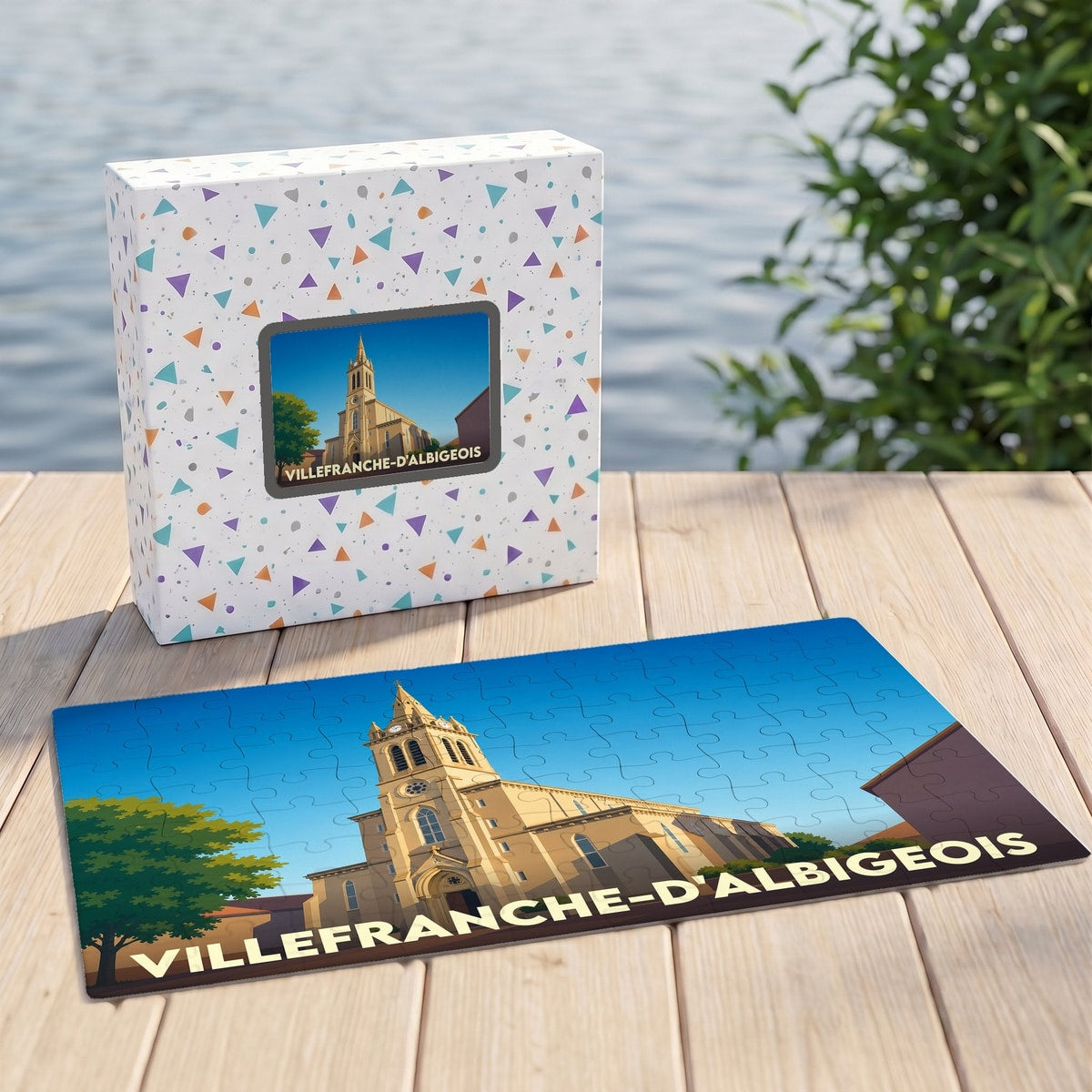 Puzzle souvenir de Villefranche-d'Albigeois illustré par un dessin stylisé de son église et présenté avec sa boîte assortie.