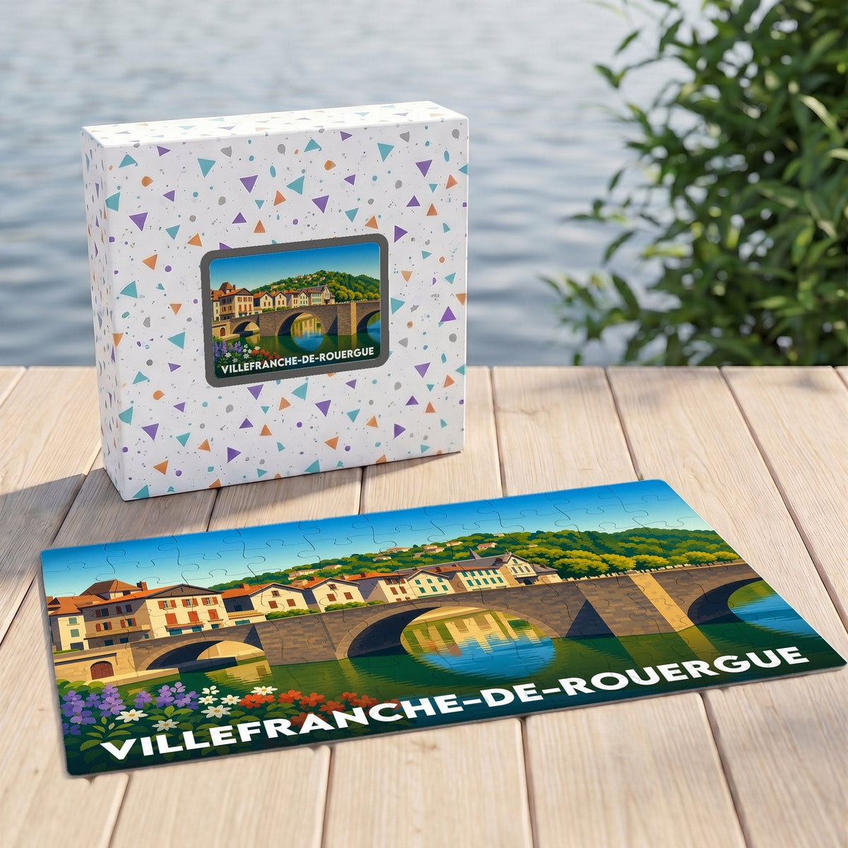 Puzzle souvenir de la ville de Villefranche-de-Rouergue avec une illustration stylisée de son pont et ses maisons en bord de rivière.