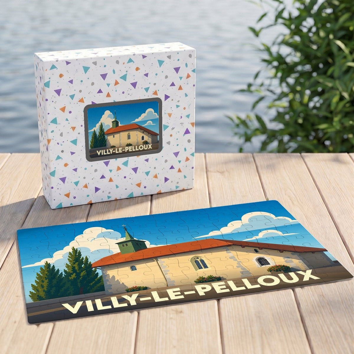 Puzzle souvenir de la ville de Villy-le-Pelloux avec son boîte, illustrant une église stylisée sous un ciel bleu.