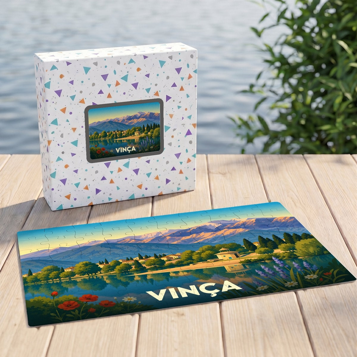 Puzzle souvenir de la ville de Vinça avec une illustration stylisée d'un paysage montagneux bordant un lac.