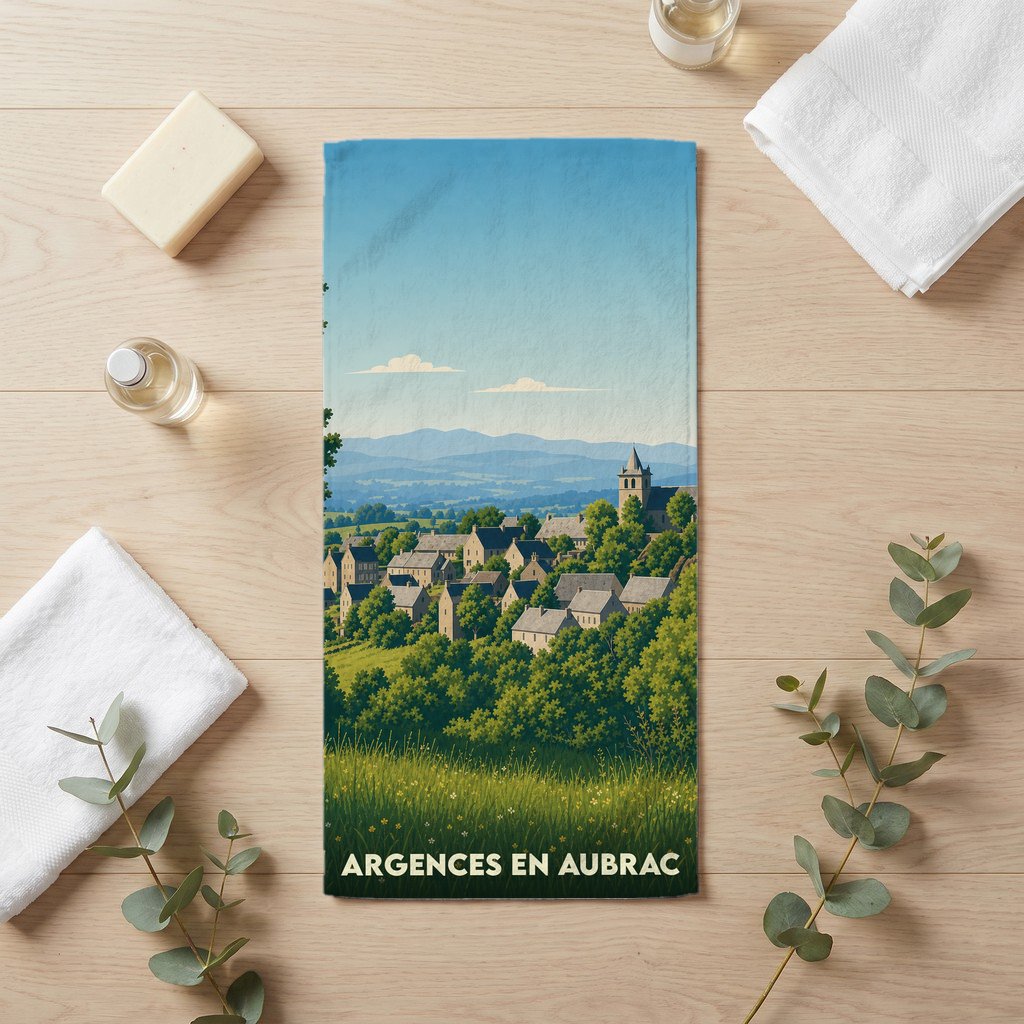 Serviette de bain souvenir de la ville d'Argences en Aubrac avec une illustration stylisée d'un village de montagne.