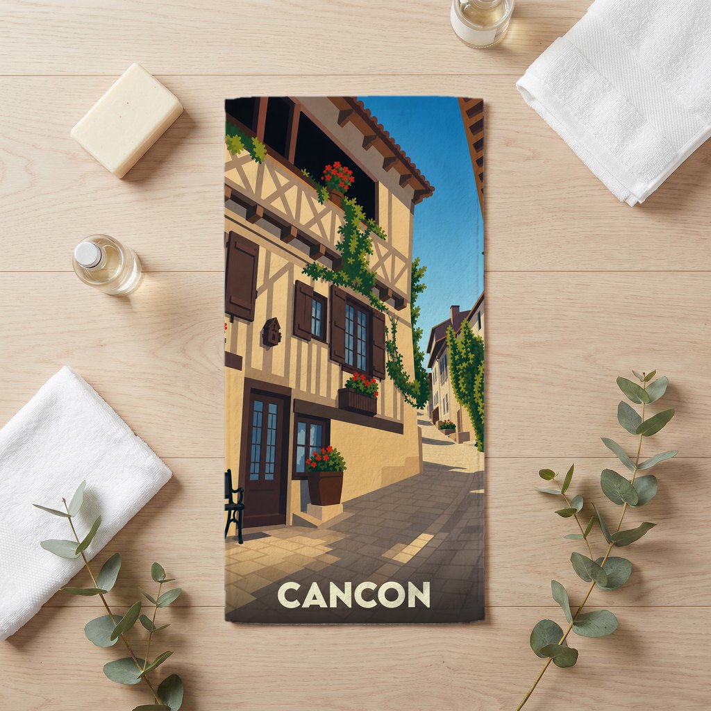 Serviette de bain souvenir de la ville de Cancon illustrée d'une ruelle médiévale pittoresque.