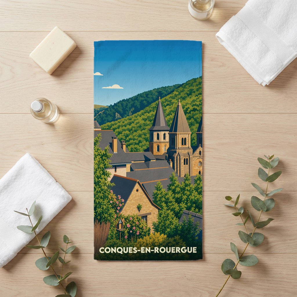 Serviette de bain souvenir de la ville de Conques-en-Rouergue avec une illustration stylisée.