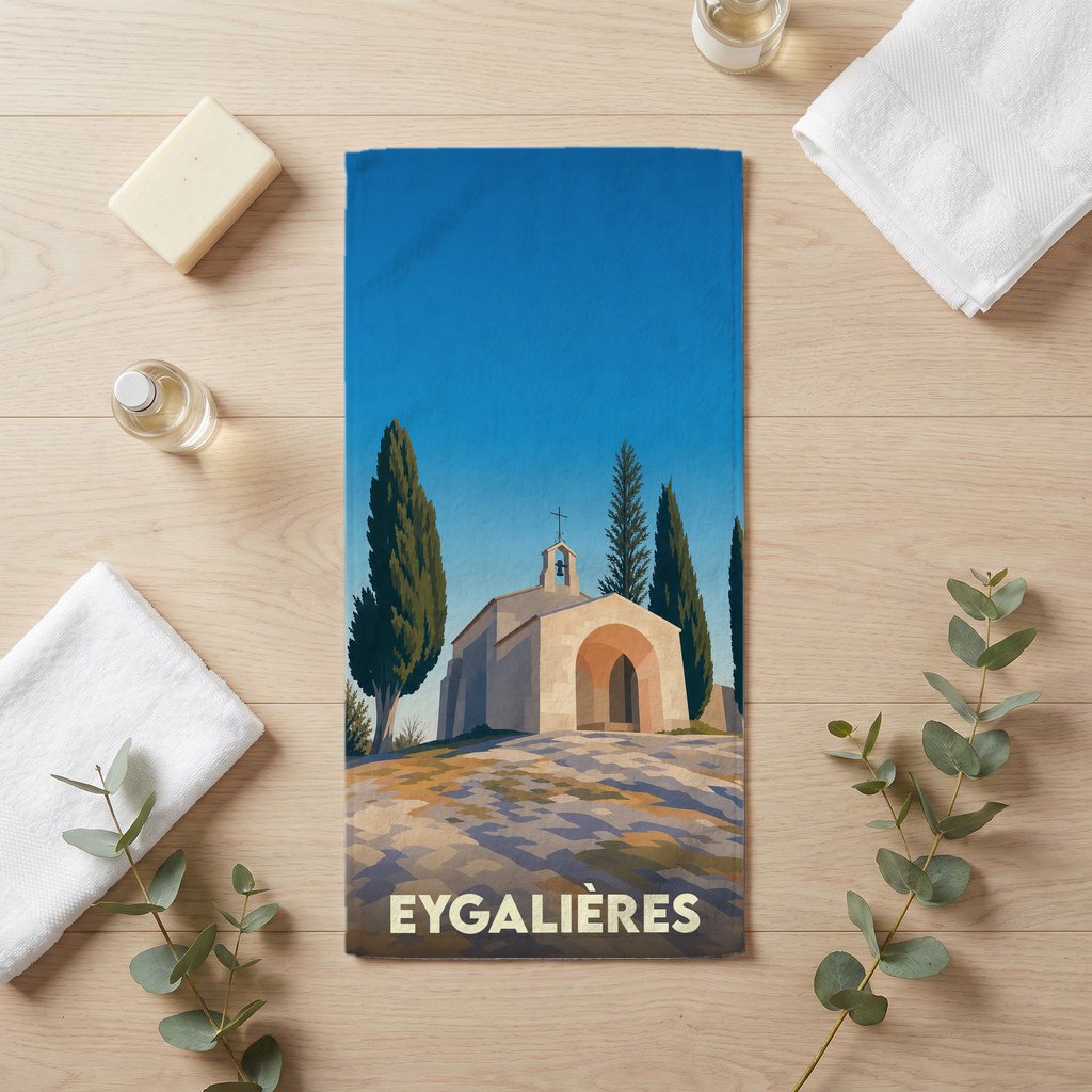 Serviette de bain souvenir de la ville d'Eygalières illustrée par une chapelle provençale stylisée.