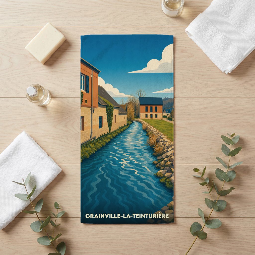 Serviette de bain souvenir de Grainville-la-Teinturière illustrée d'un paysage de rivière et de maisons typiques.