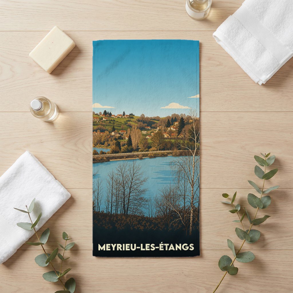 Serviette de bain souvenir de Meyrieu-les-Étangs avec une illustration stylisée d'un paysage de lac et de collines.