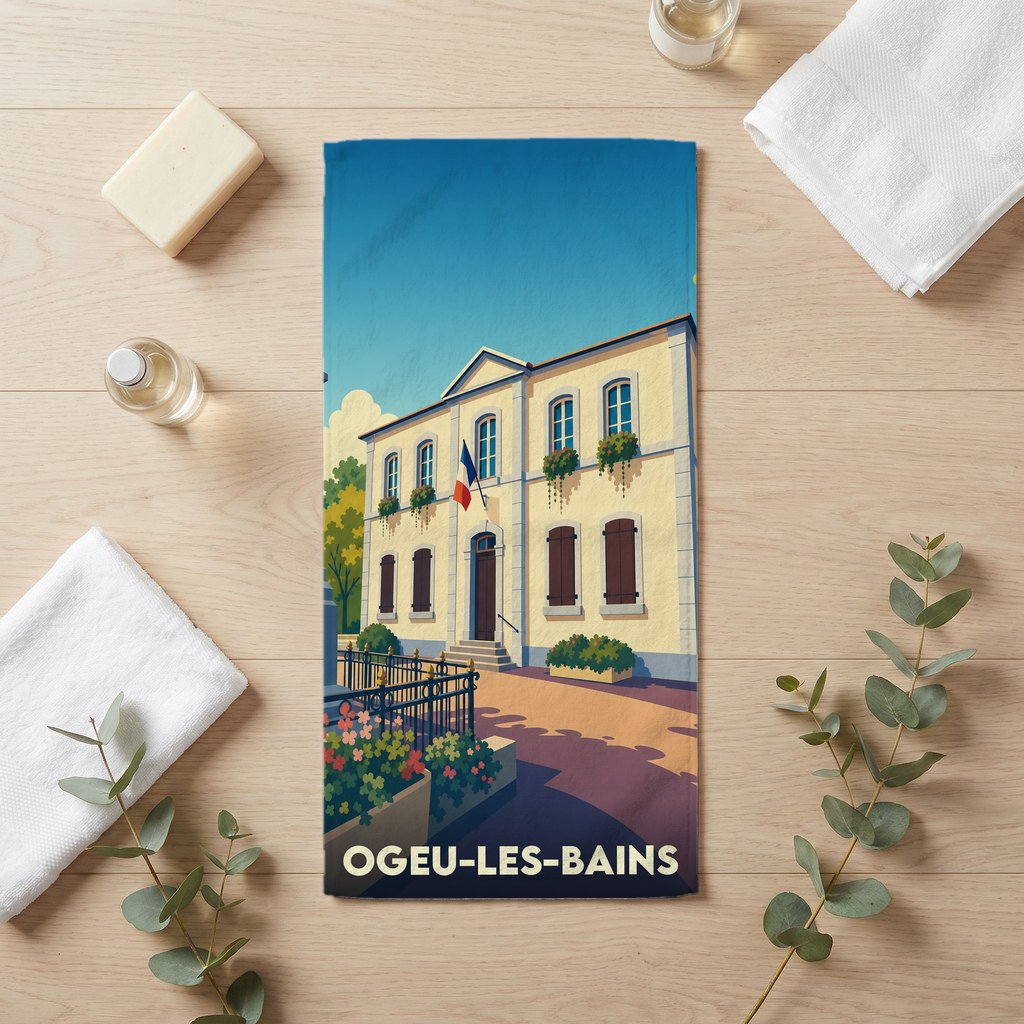 Serviette de bain souvenir de la ville d'Ogeu-les-Bains avec une illustration stylisée d'un bâtiment municipal.
