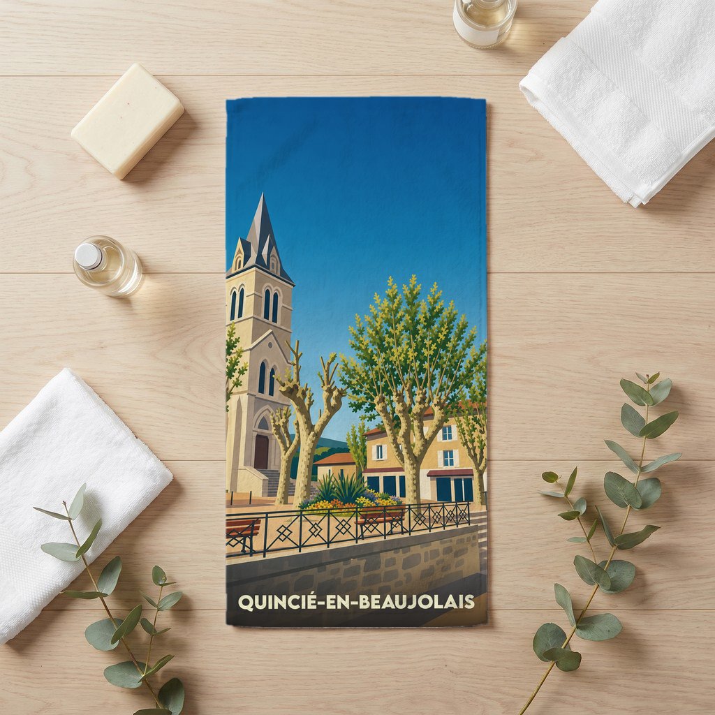 Serviette de bain souvenir de la ville de Quincié-en-Beaujolais avec une illustration stylisée de son église et de sa place.
