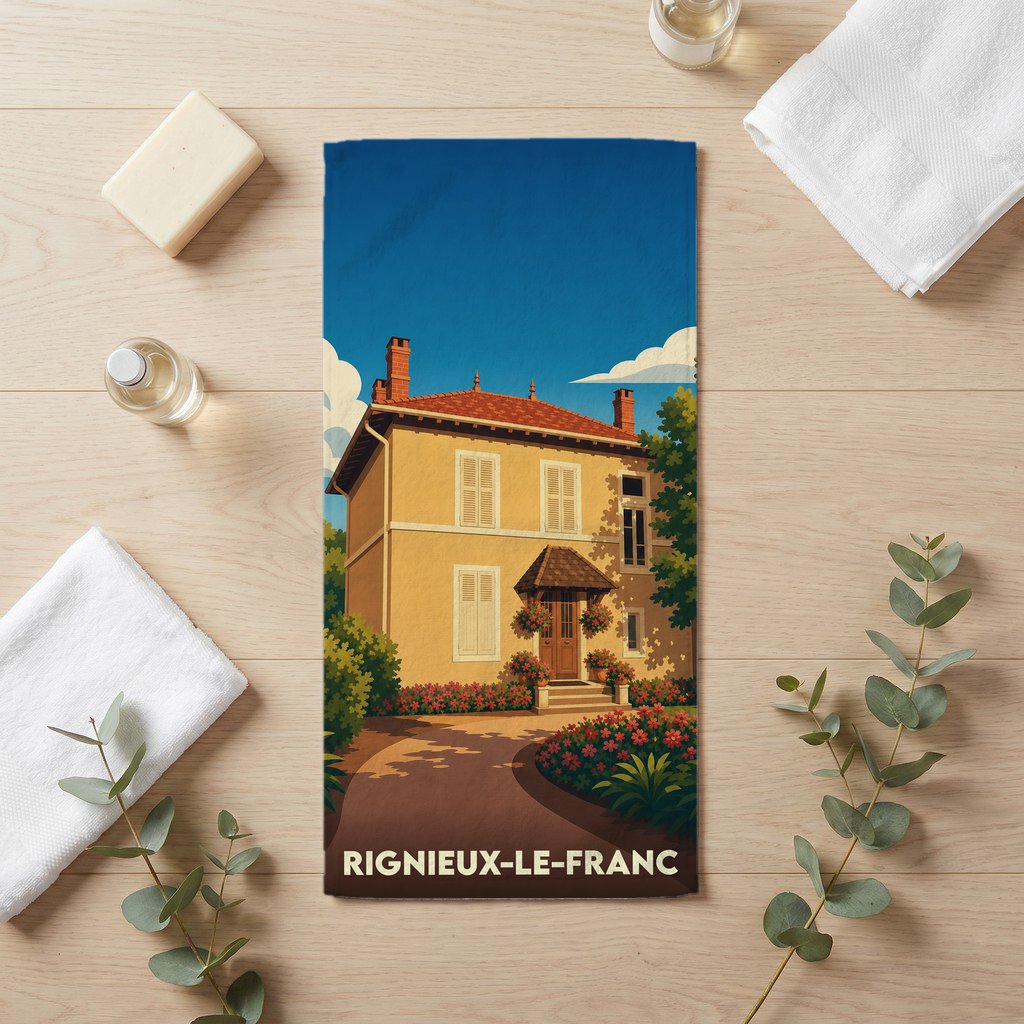 Serviette de bain souvenir de la ville de Rignieux-le-Franc avec une illustration stylisée d'une maison de campagne.