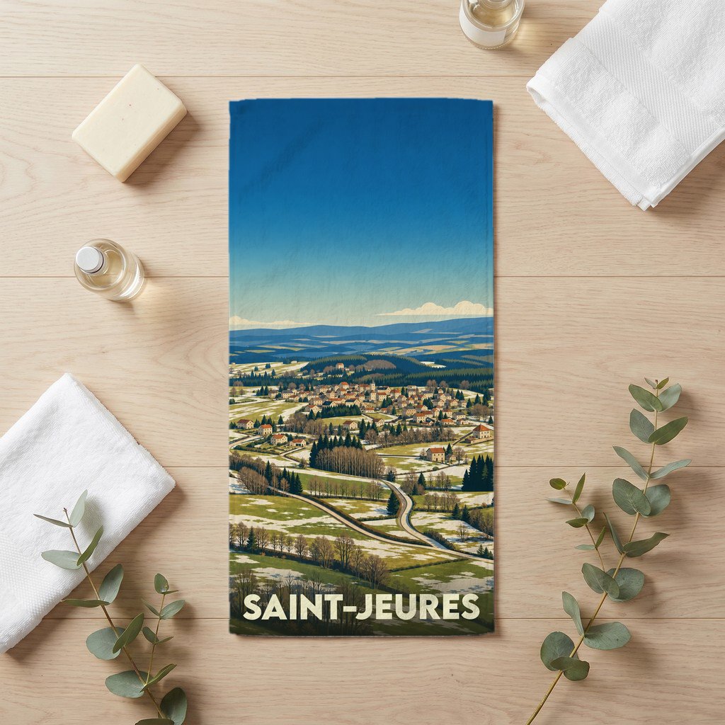 Serviette de bain souvenir de la ville de Saint-Jeures avec une illustration stylisée d'un paysage de campagne.