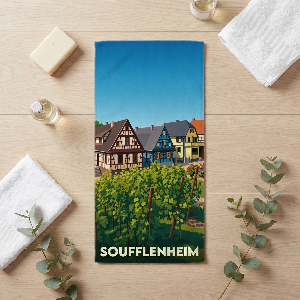 Serviette de bain souvenir de la ville de Soufflenheim avec une illustration stylisée de maisons à colombages et d'un vignoble.