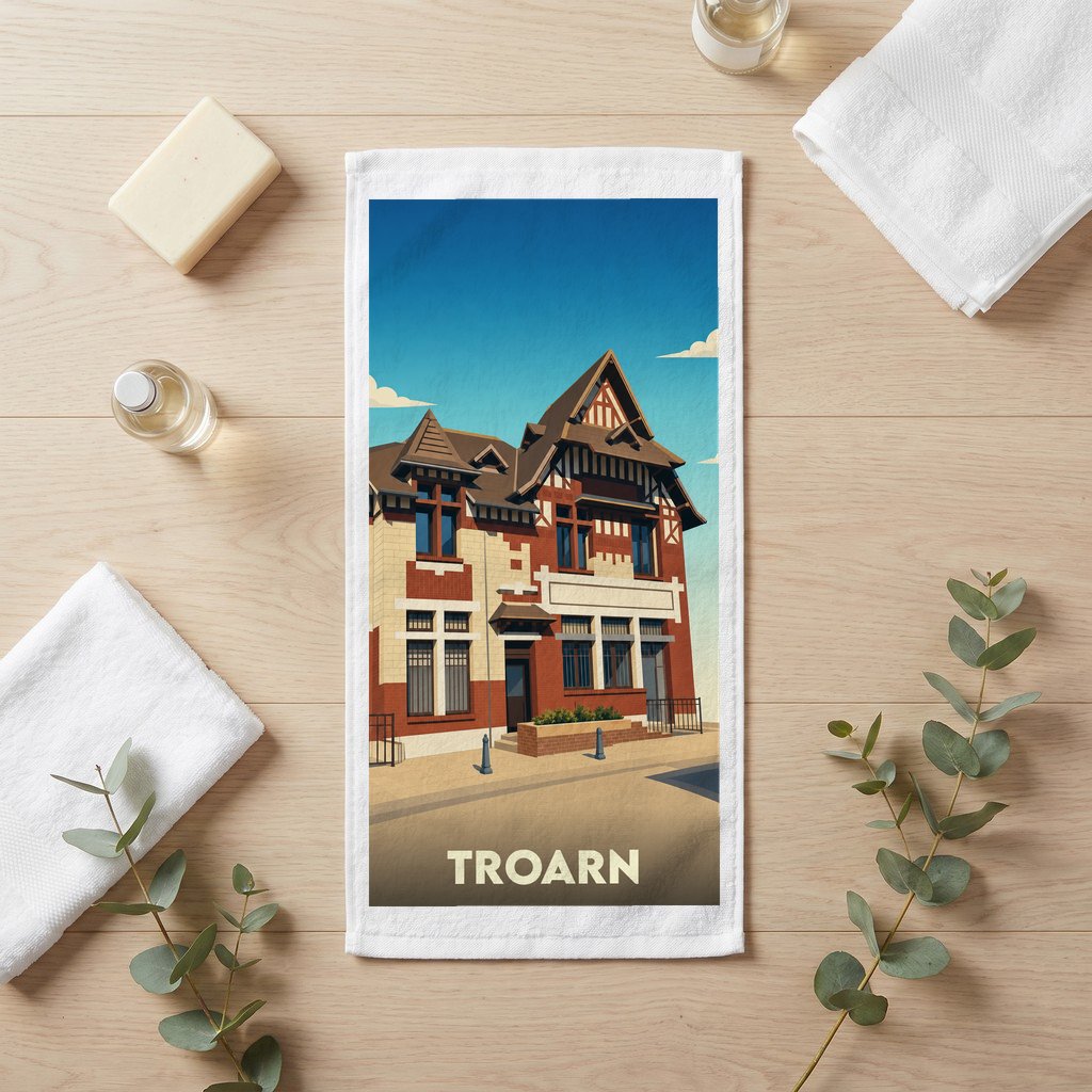 Serviette de bain souvenir de la ville de Troarn avec une illustration stylisée d'un bâtiment typique.