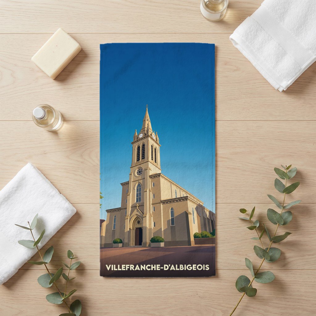 Serviette de bain souvenir de Villefranche-d'Albigeois illustrée d'une église de style néogothique sous un ciel bleu.