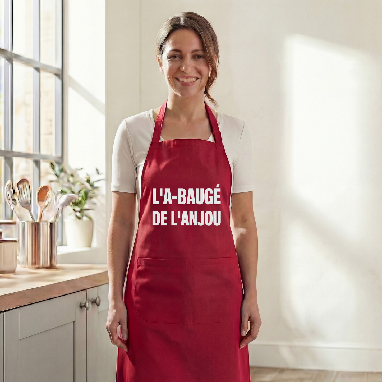 Tablier de cuisine rouge avec une inscription blanche en souvenir de la ville de Baugé-en-Anjou.