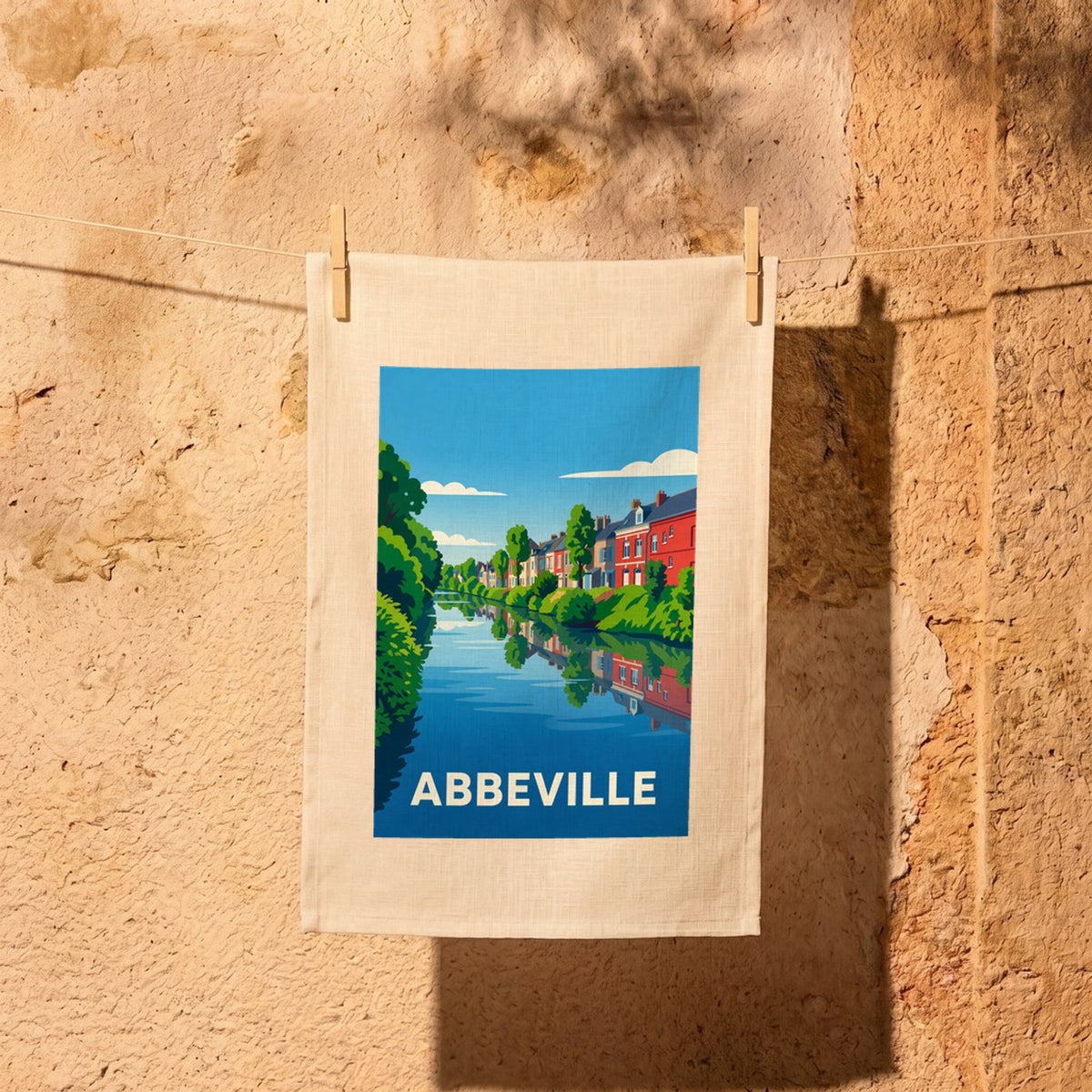 Torchon souvenir de la ville d'Abbeville avec une illustration stylisée de maisons colorées se reflétant dans l'eau.