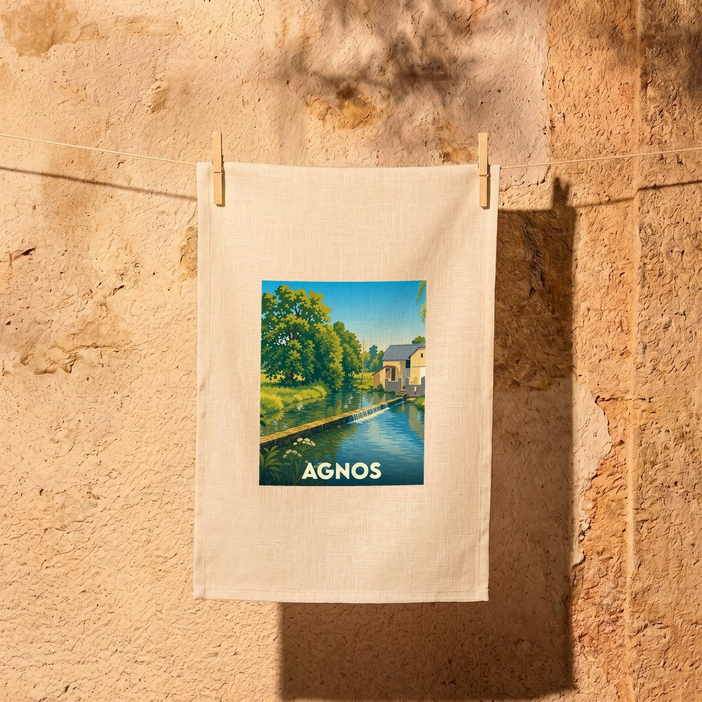 Torchon souvenir de la ville d'Agnos illustré par un paysage bucolique de rivière et de moulin.