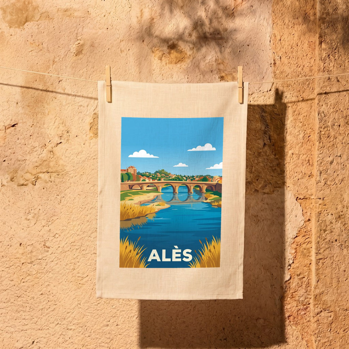 Torchon souvenir de la ville d'Alès avec une illustration stylisée représentant un pont enjambant une rivière.