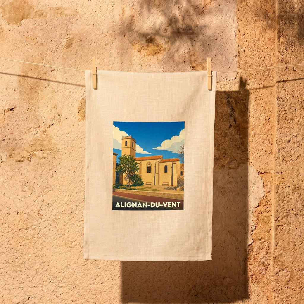 Torchon souvenir de la ville d'Alignan-du-vent avec une illustration stylisée de son église sous un ciel bleu.