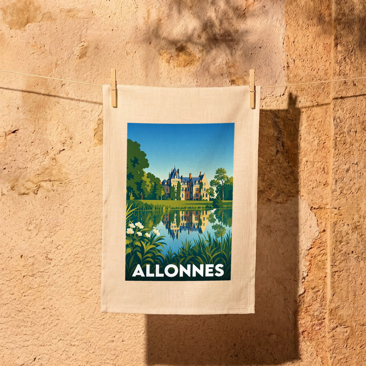 Torchon souvenir de la ville d'Allonnes avec une illustration stylisée d'un château se reflétant dans l'eau.