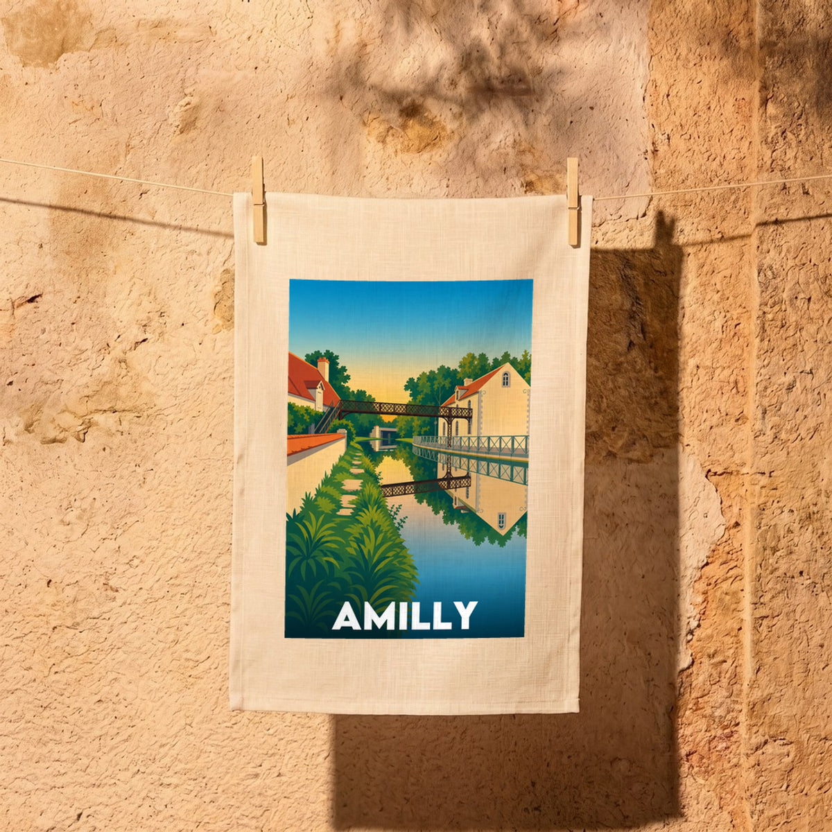 Torchon souvenir de la ville d'Amilly avec une illustration stylisée d'un canal.