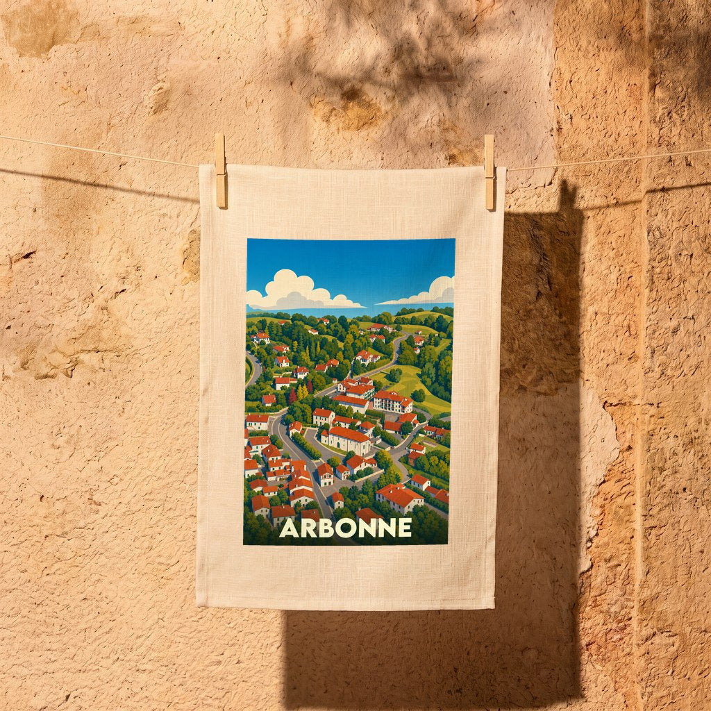 Torchon souvenir de la ville d'Arbonne avec une illustration stylisée d'un village vallonné.