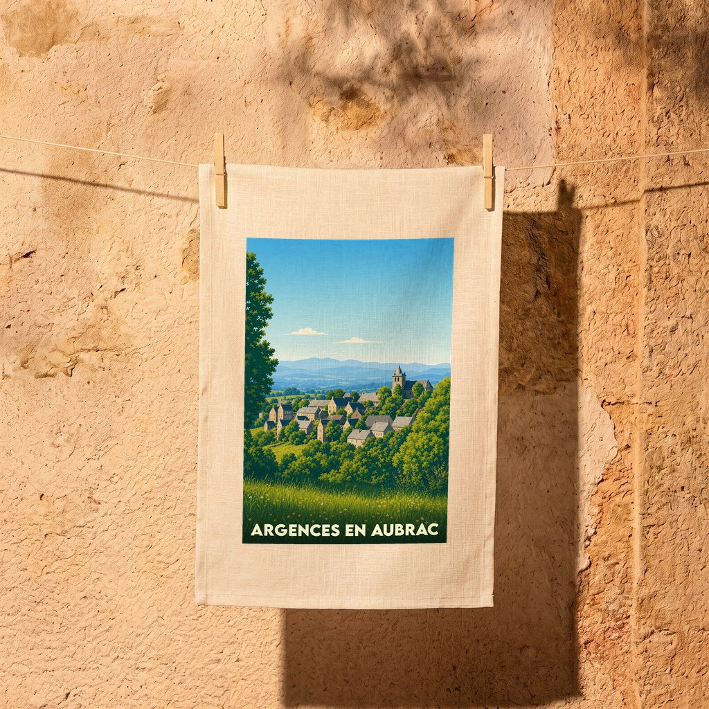 Torchon souvenir de la ville d'Argences en Aubrac avec une illustration de paysage stylisée.