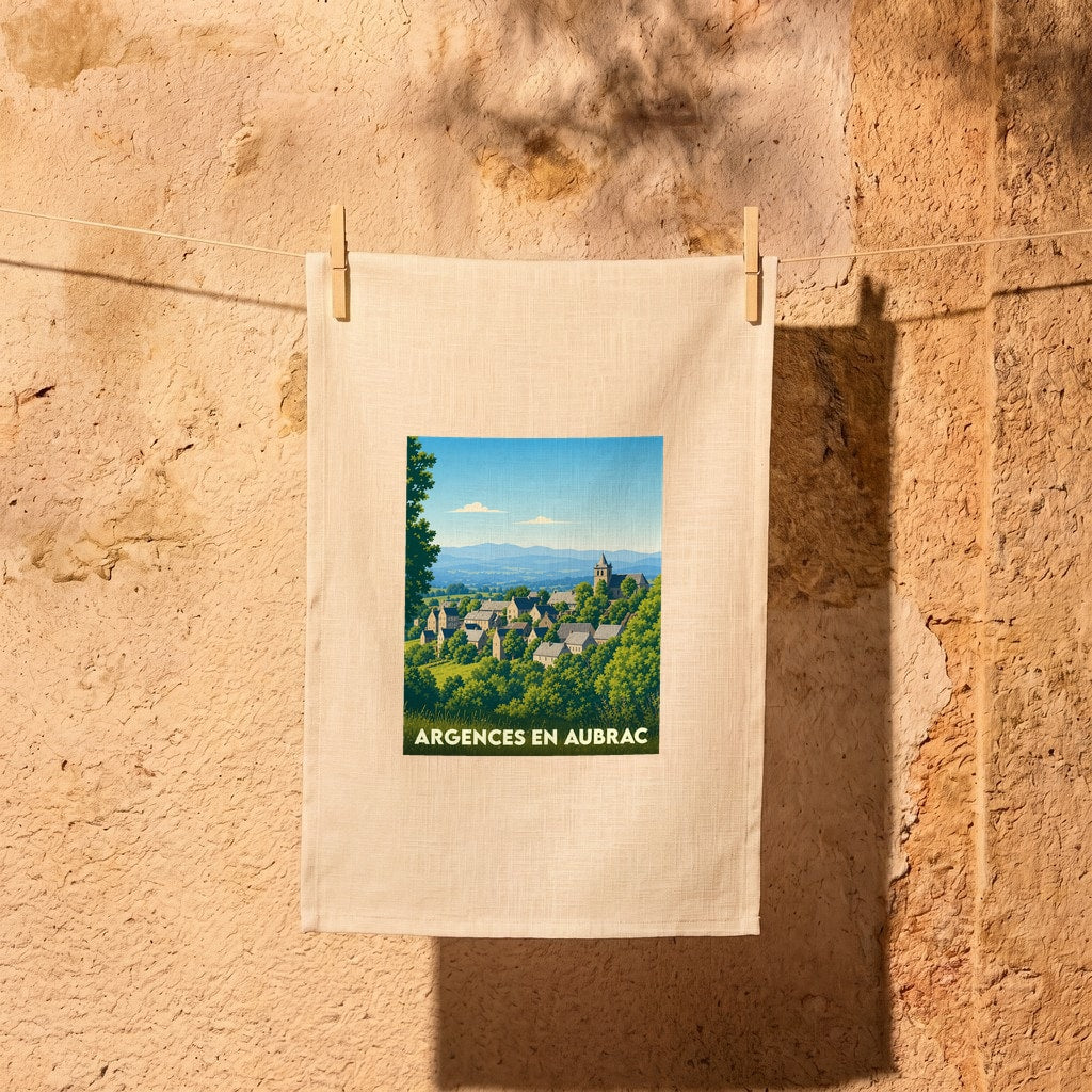 Torchon souvenir de la ville d'Argences en Aubrac avec une illustration de paysage stylisée.