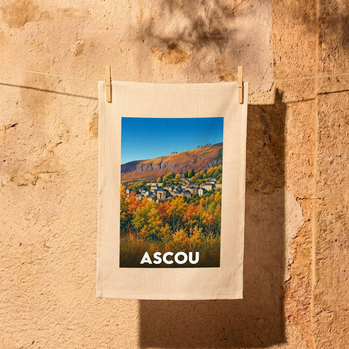 Torchon souvenir de la ville d'Ascou avec une illustration stylisée de son paysage montagneux en automne.