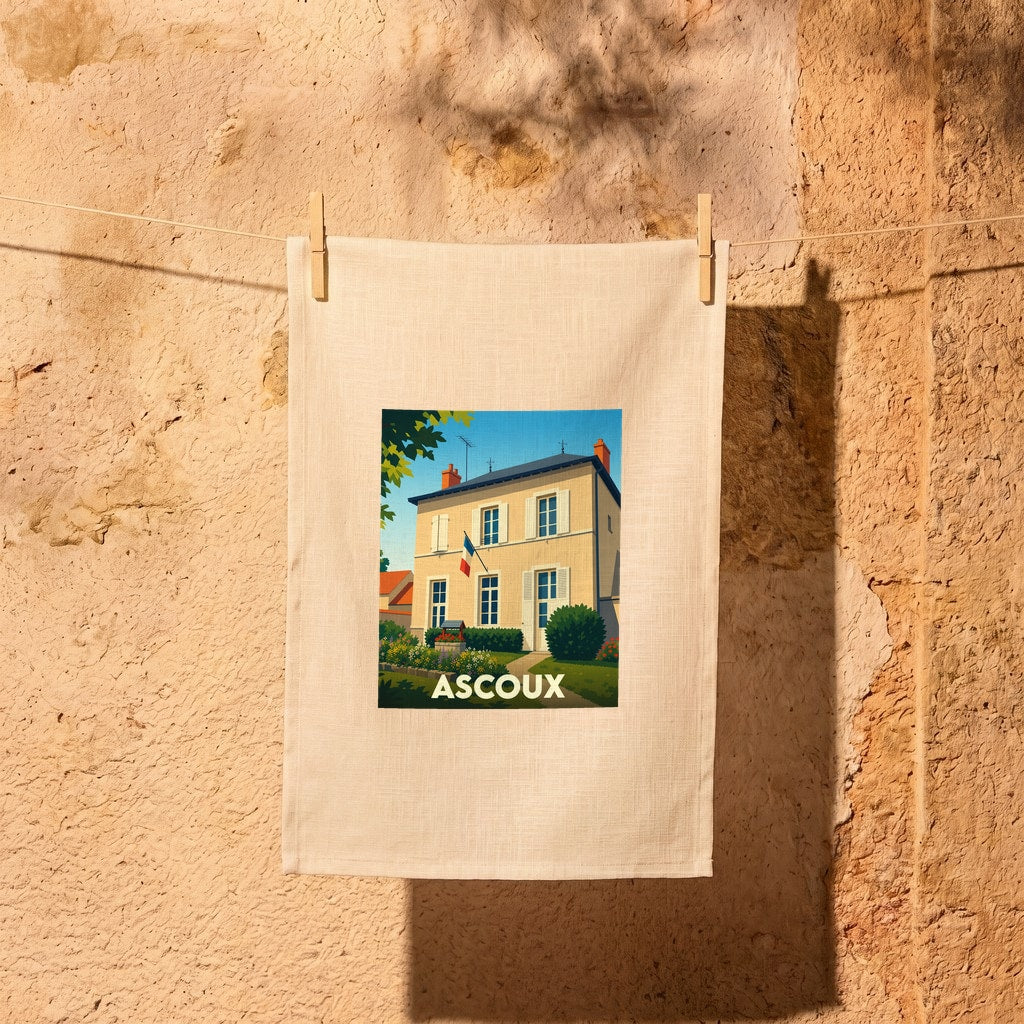 Torchon souvenir de la ville d'Ascoux orné d'une illustration stylisée représentant une bâtisse typique sous un ciel bleu.