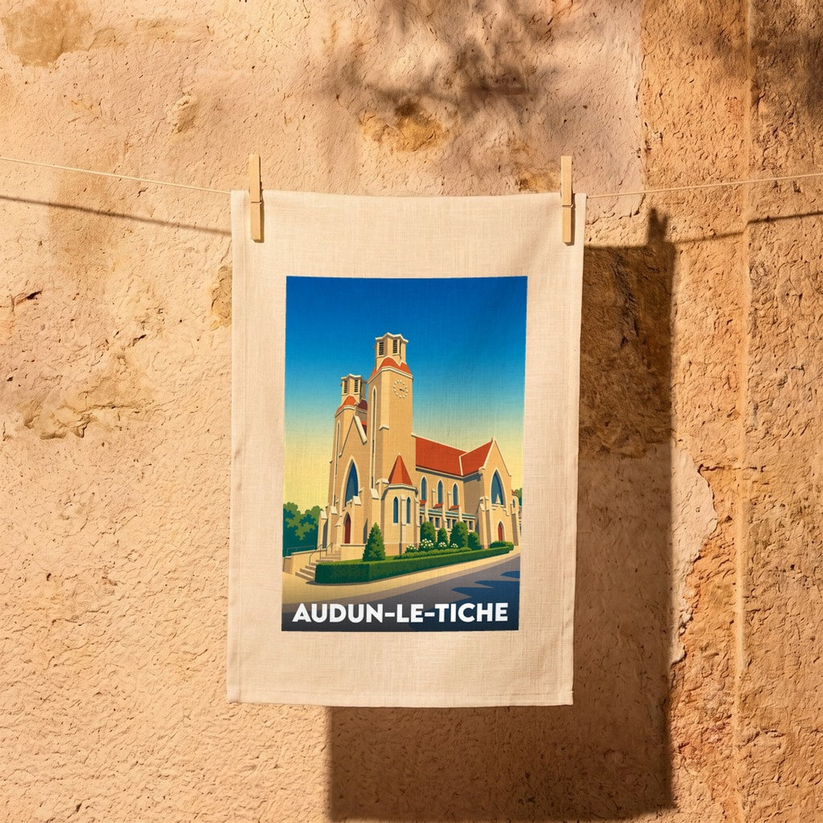 Torchon souvenir de la ville d'Audun-le-Tiche avec une illustration stylisée de son église.