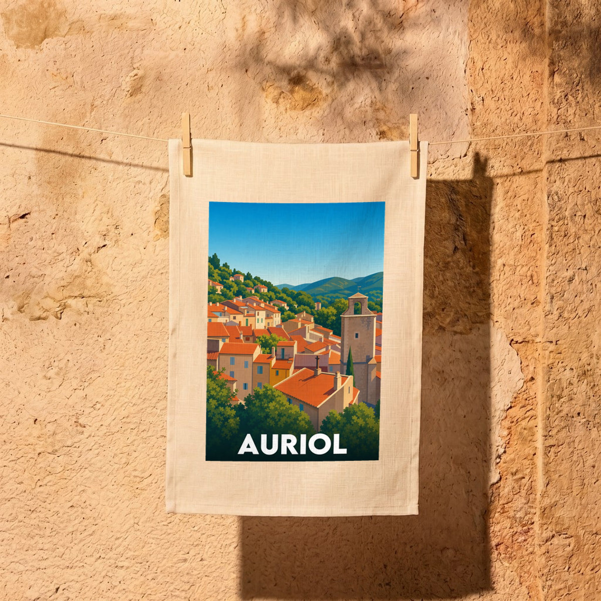 Torchon souvenir de la ville d'Auriol illustrant une vue stylisée de ses toits provençaux et de ses collines.