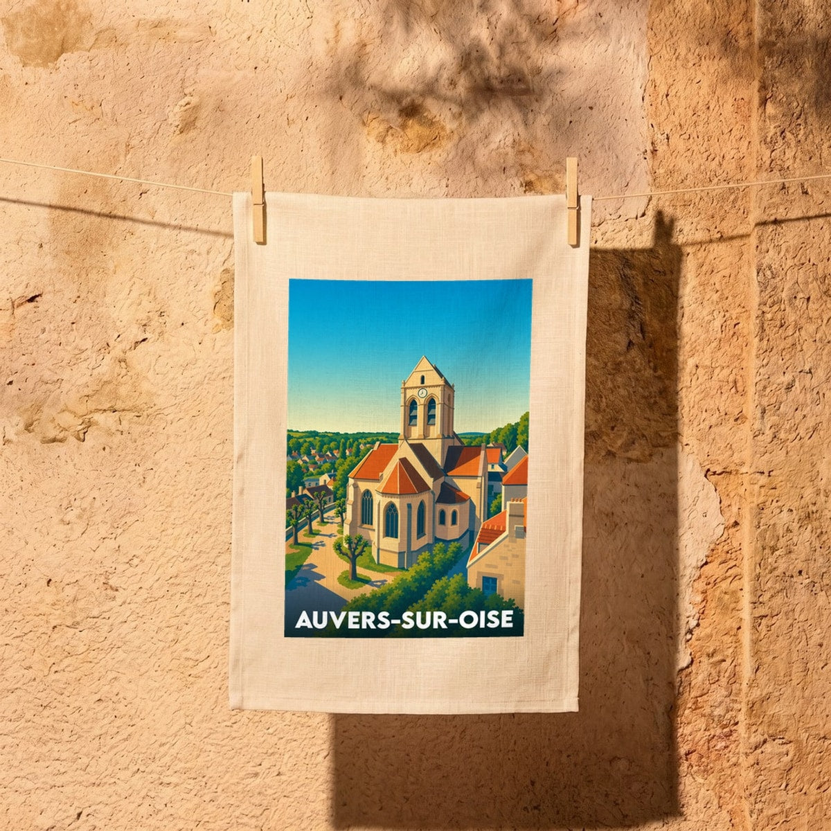 Torchon souvenir de la ville de Auvers-sur-Oise illustrant son église emblématique dans un style graphique coloré.