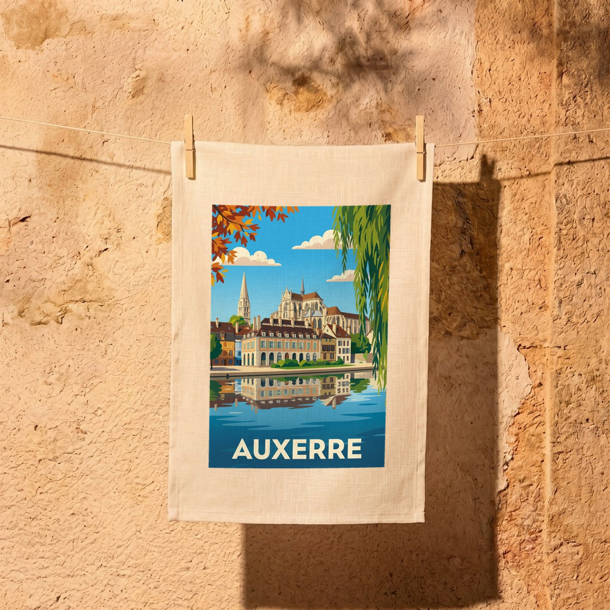 Torchon souvenir de la ville d'Auxerre avec une illustration stylisée de ses monuments au bord de l'eau.