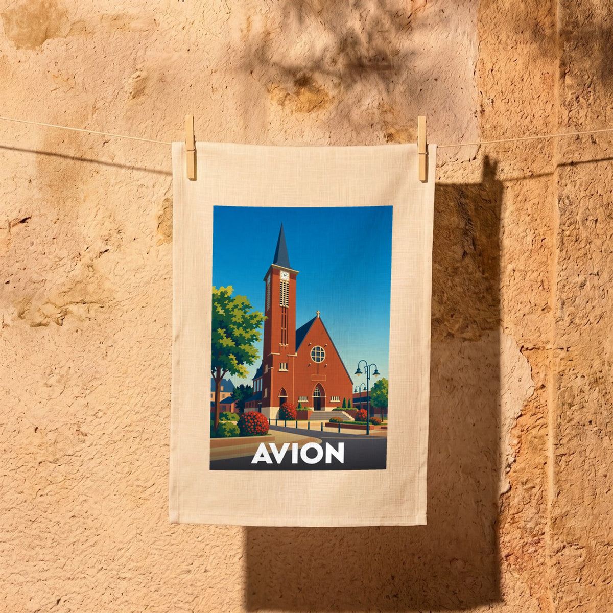 Torchon souvenir de la ville d'Avion avec une illustration stylisée de son église en briques rouges.